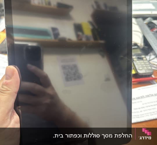 אדם מחזיק טאבלט עם כבל טעינה מחובר